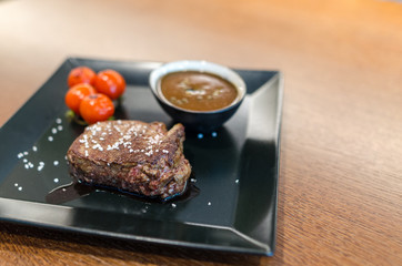 Steak with french fries on wooden table