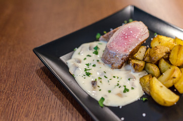 Steak with french fries on wooden table