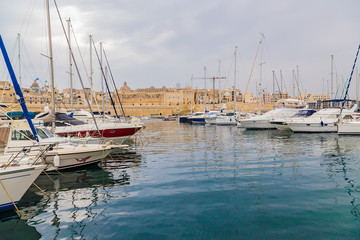 Obraz premium Birgu, Malta. Yachts in the background of the fortress and the city