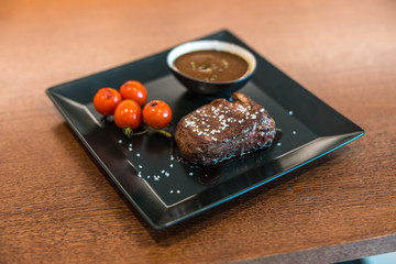 Steak with french fries on wooden table