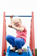 healthy childhood in the city - portrait of a cheerful active girl on a playground