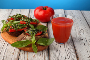 Tomato bruschetta and a glass of tomato juice.