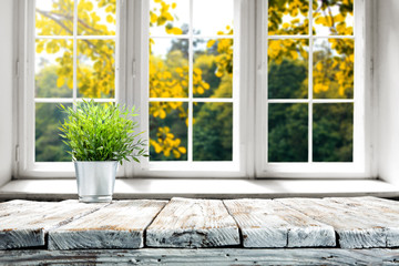 Desk of free space and autumn background with window 
