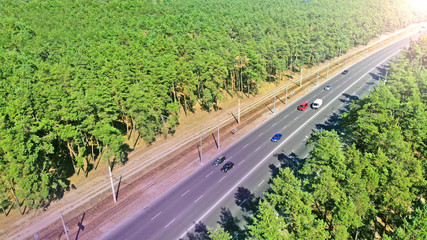 Naklejka premium Aerial photo of a highway traffic between city greenery