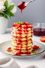 Pancakes with strawberries, topped yoghurt and strawberry syrop