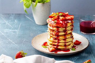Pancakes with strawberries, topped yoghurt and strawberry syrop