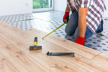 Handyman installing new laminated wooden floor