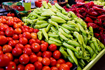 Heap of ripe big green, red peppers and tomatoes at street market for sale