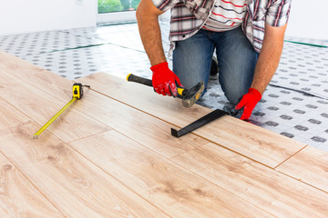 Handyman installing new laminated wooden floor