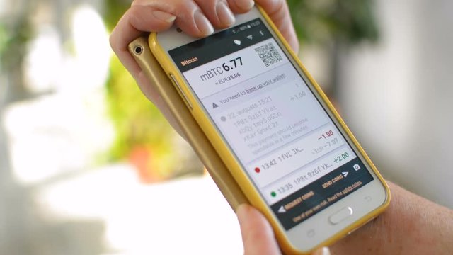 Bitcoin wallet balance opened on mobile phone smartphone screen by a businesswoman, be your own bank concept