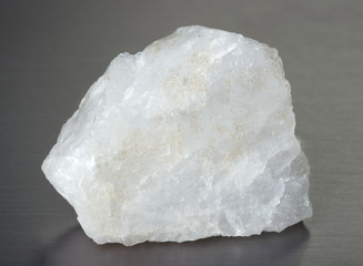 Specimen of mineral quartz on gray background. Quartz crystals have piezoelectric properties. 
