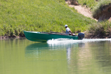 a man drives a motor boat on the lake