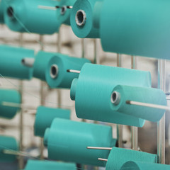 Modern Textile Factory. Rows of automated machines for yarn manufacturing.