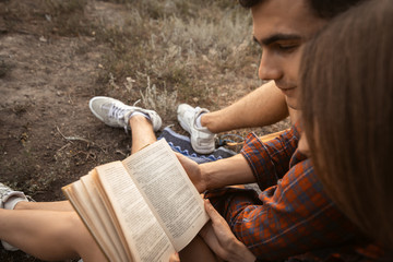 guy with a girl sit next to him and read a book