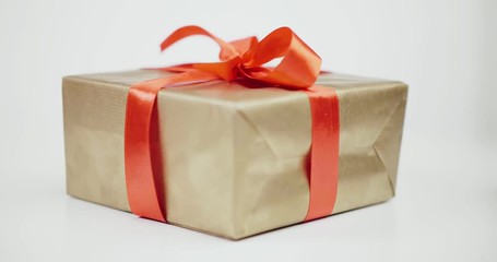 Present wrapped with golden paper and tied red ribbon bow - Powered by Adobe