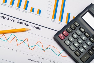 Obraz premium Pencil and Calculator on Business Graphs and Charts