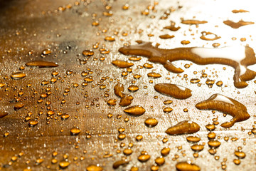 a drop of water golden flowers, on a yellow surface during sunset