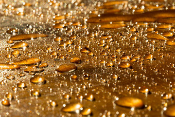 a drop of water golden flowers, on a yellow surface during sunset