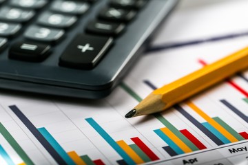 Closeup of Calculator and Pencil on Business Graphs