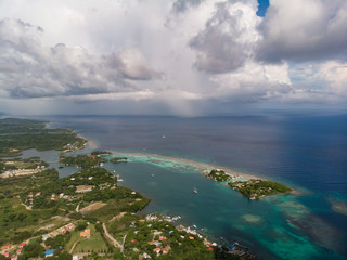 Aerial Of Tropical Rain Over Caribbean Sea With Island Foreground