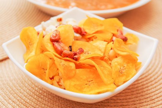 Close up of Banana chips chifles lying in small white bowl