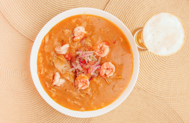 Above view of Ecuadorian food: shrimp cebiche with a glass of beer in wooden table background
