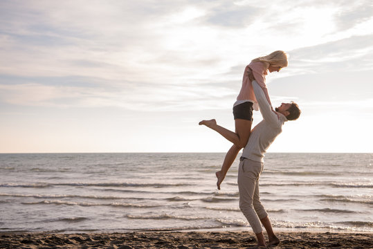 Loving young couple on a beach at autumn sunny day