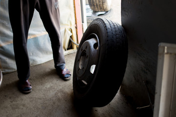 engineer balancing car wheel on balancer in workshop