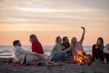 Friends having fun at beach on autumn day