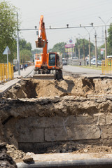 Repair of the damaged road - rupture of the pipeline, excavator during operation