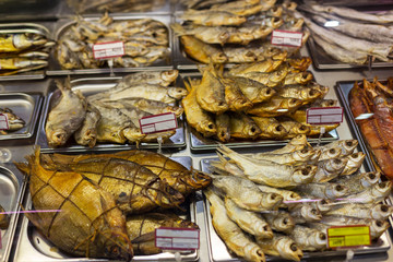 various types of smoked fish in a supermarket on a glass refrigerator