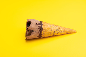 side view chocolate flavor ice cream cone on a yellow background