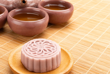 studio shoot of modern style Chinese mooncake with tea and teapot on bamboo mat