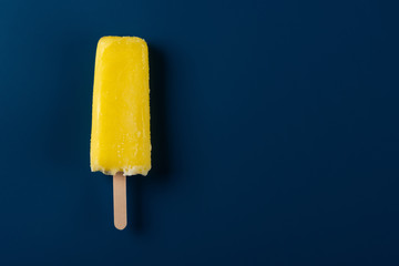 yellow popsicle on a dark blue background