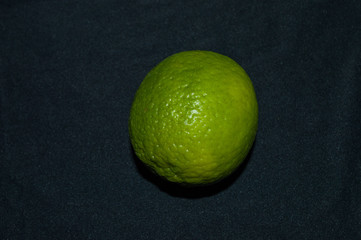 green lime tahiti, or taiti lemon or Citrus latifolia, isolated on black background