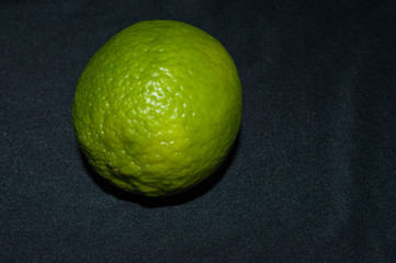 green lime tahiti, or taiti lemon or Citrus latifolia, isolated on black background