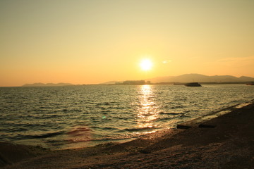 金色に輝く夕日と砂浜
