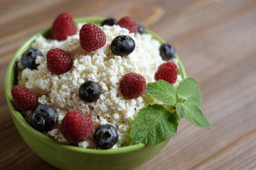 Cottage cheese and blueberry and mint in a bowl on a table.