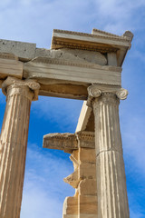 Looking up at detail of reconstructed columns on the Parthenon on the Accropolis in Athens Greece with beautiful blue sky with clouds behind