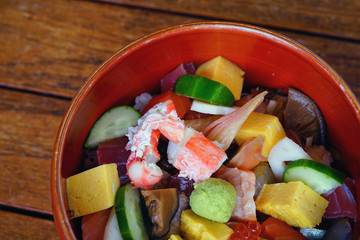 Bowl of chirashi sushi with mixed raw fish and salmon roe over rice