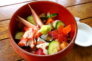 Bowl of chirashi sushi with mixed raw fish and salmon roe over rice