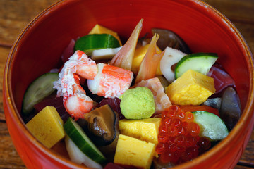 Bowl of chirashi sushi with mixed raw fish and salmon roe over rice