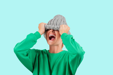 Crying emotional angry woman is pulling wool hat over her eyes