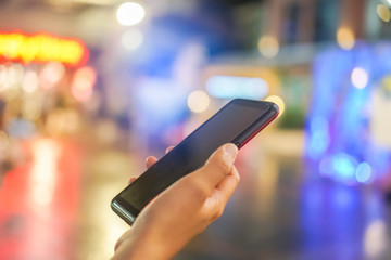 Woman hand using smartphone in mall