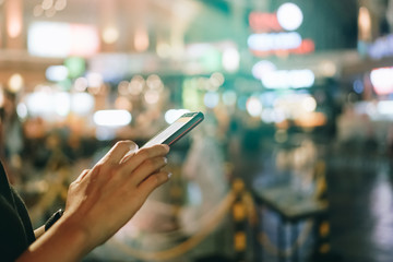 Woman hand using smartphone in mall