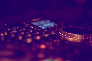 Dj mixes the track in the nightclub at party. DJ hands in motion