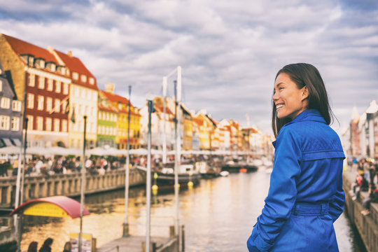 Tourist in Copenhagen. Chinese Asian woman traveler walking in Nyhavn visiting Denmark. City travel, tourism in Scandinavia.