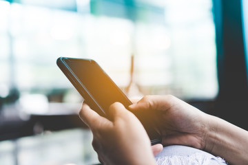 Woman hand using smartphone or tablet to do business, financial or trading stock forex market in park outdoor nature road background.