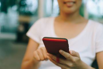 Woman hand using smartphone or tablet to do business, financial or trading stock forex market in park outdoor nature road background.