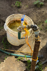 Fototapeta premium An original irrigation system consisting of a bucket with a crane inside a large private greenhouse. Private home agriculture.